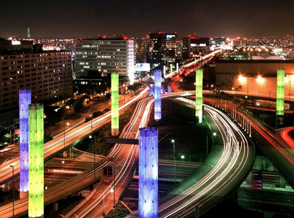 LAX Gateway Pylon Project (Photo: Greg Wenger), kinetic light installation, 2000, 11 pylons, 6’ diameter, ranging from 25’ to 60’ on Century Blvd. and 15 pylons, 12’ diameter, 100’ high at the intersection of Century Boulevard & Sepulveda Boulevard, translucent glass, computer-driven kinetic light display